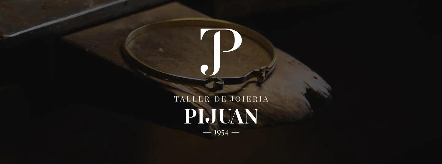 Una peça d'or sobre la fusta del banc de treball del taller Pijuan