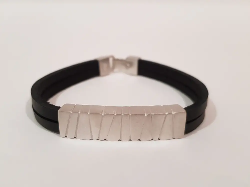 Polsera de cuir amb una placa de metall tallada a mà, feta al taller de Pijuan
